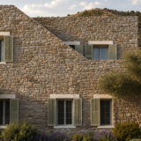 Stone façade with green shutters at an ERAWA residence in Oitylo, Mani